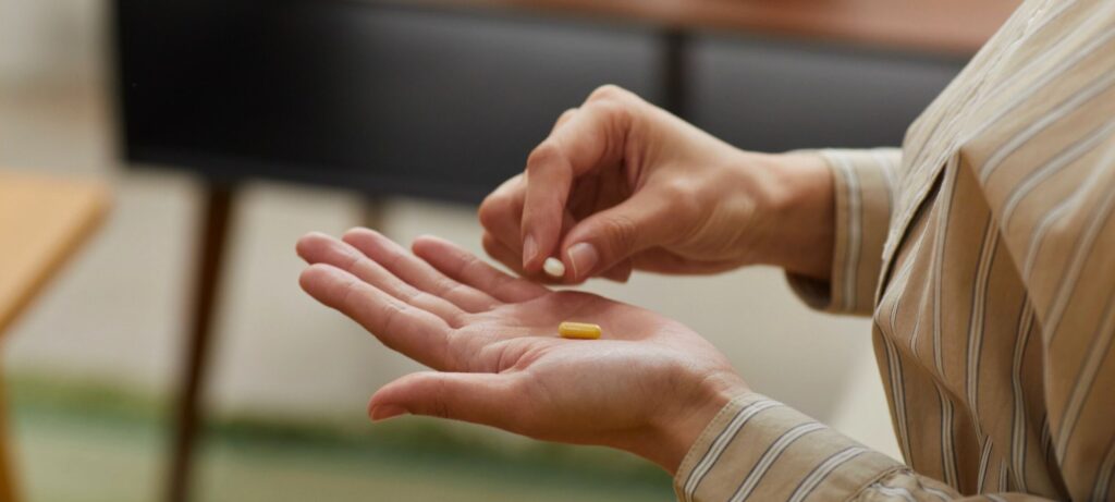 woman holding supplements in hand