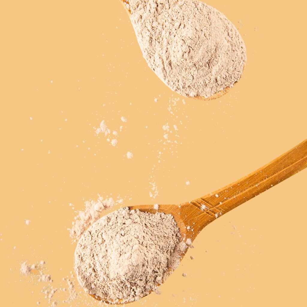 wood spoons with white collagen powder on them